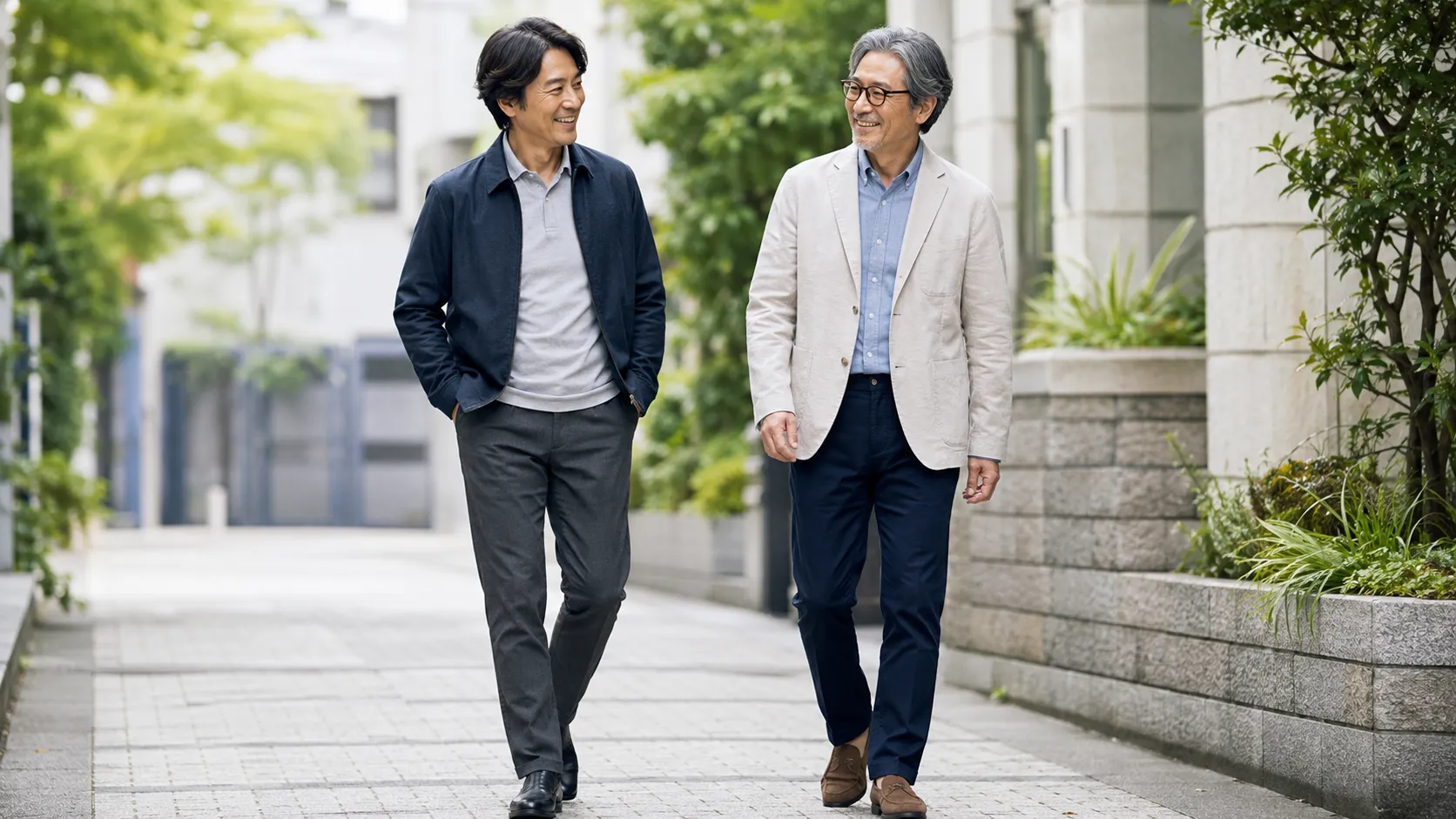 ジャケットとテーパードパンツを着用して街を歩く日本人男性2人の、40代・50代向け清潔感のあるメンズコーデ