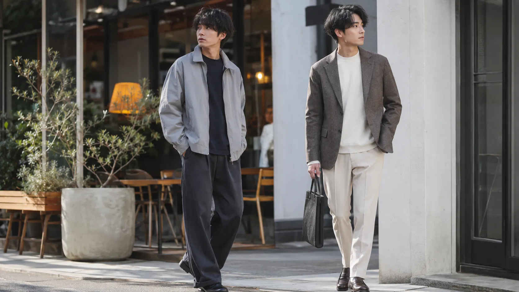 カフェ前に立つ日本人男性2人の、ワイドパンツを使ったカジュアルコーデとジャケットを使った20代向けきれいめコーデ