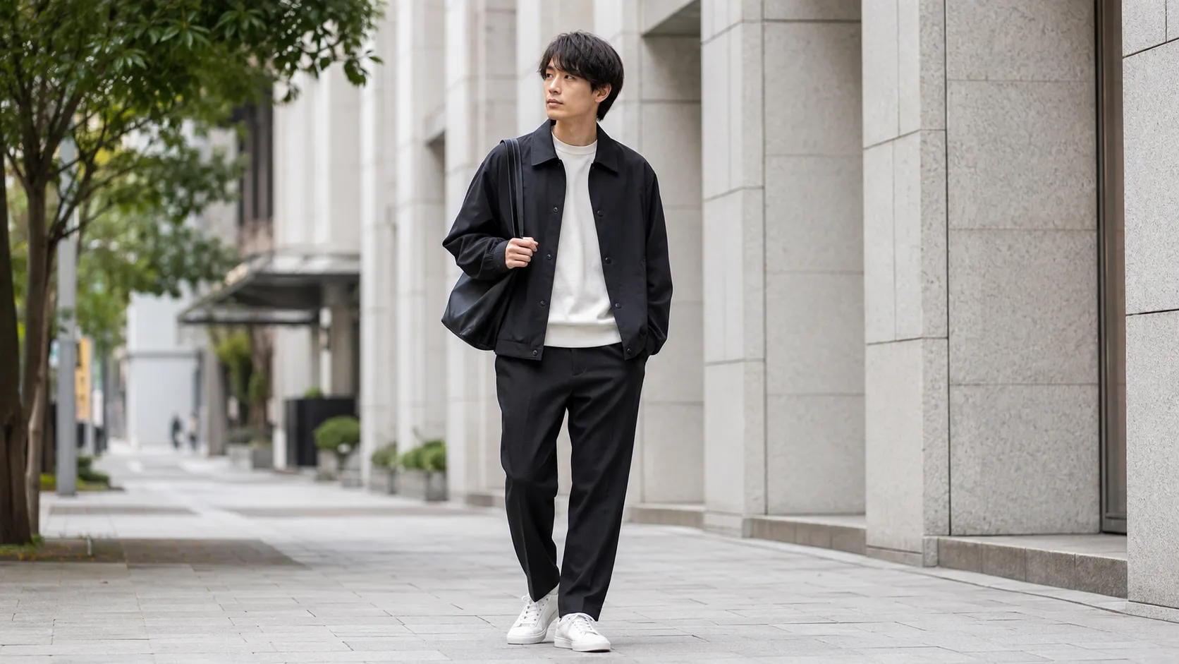 黒ブルゾンとスラックスを合わせた20代男性の都会的なメンズコーデ